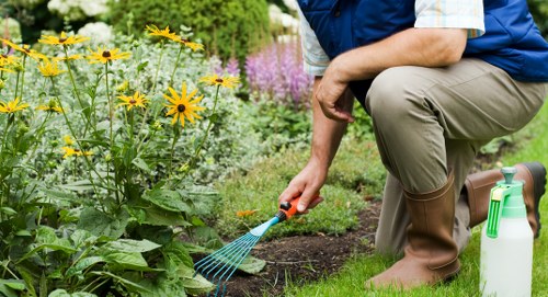 Workers setting up safety signs near a public footpath during garden work